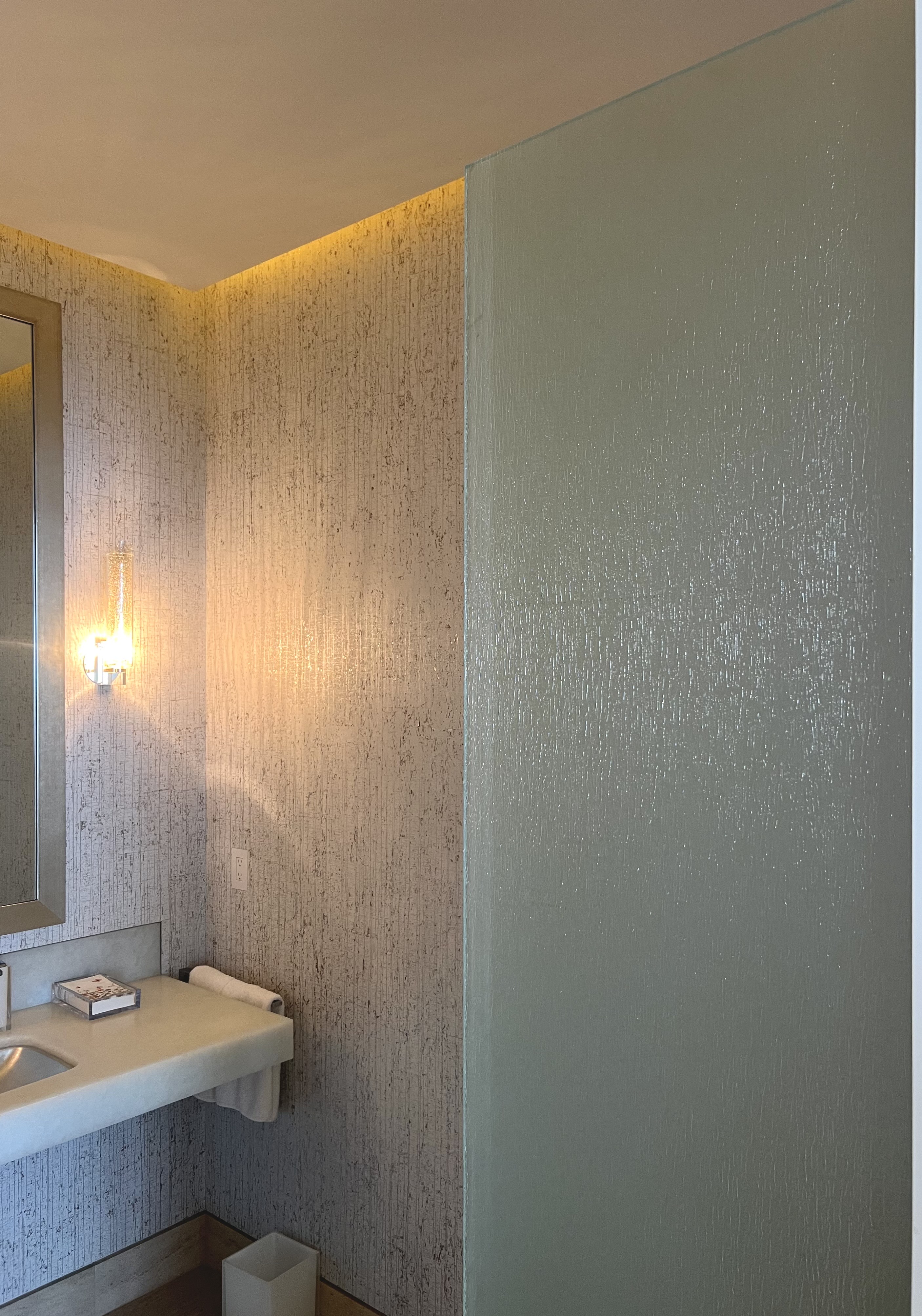 Textured glass partition in warm-lit bath