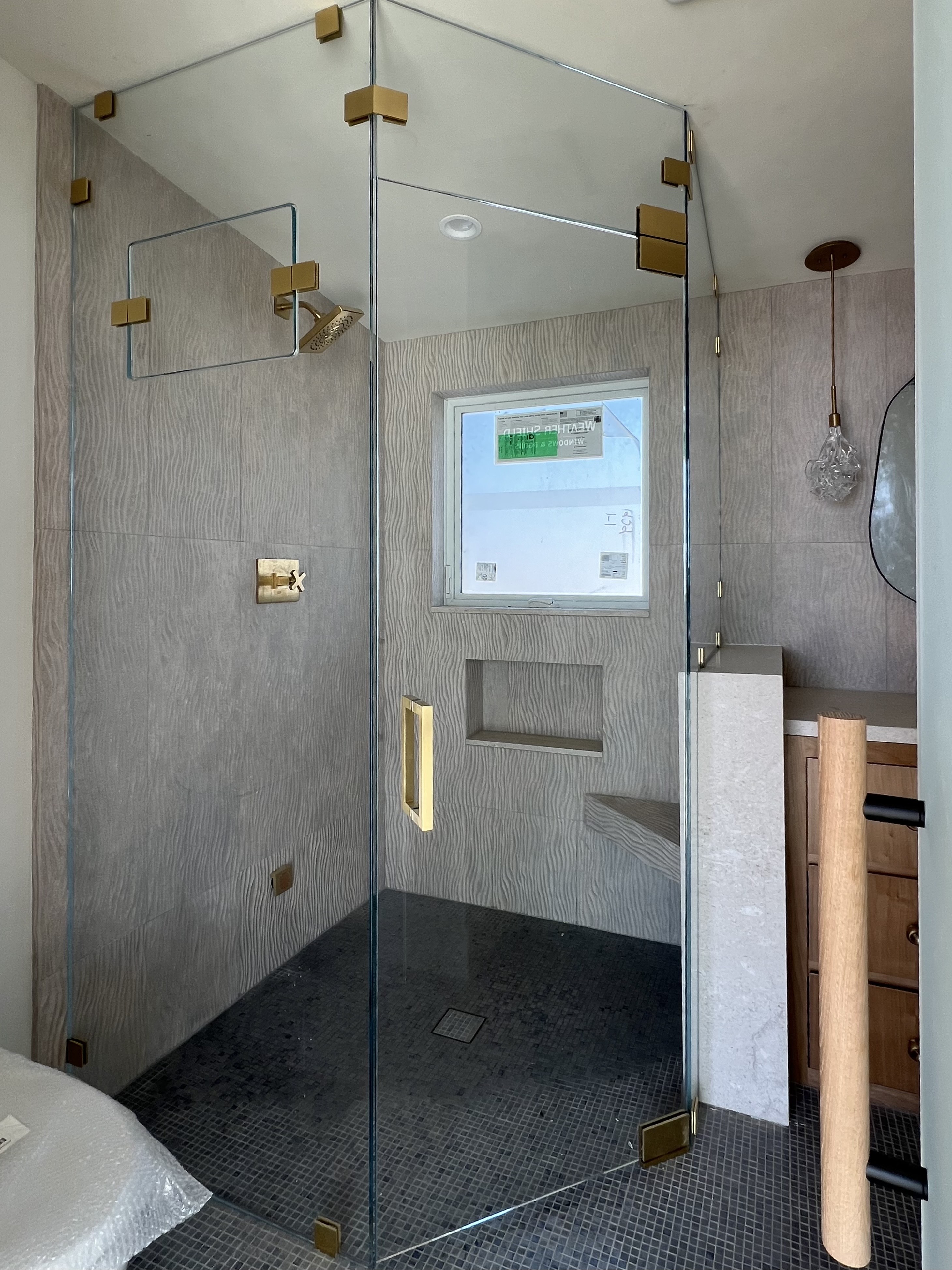 Large walk-in shower with brass hardware and bench