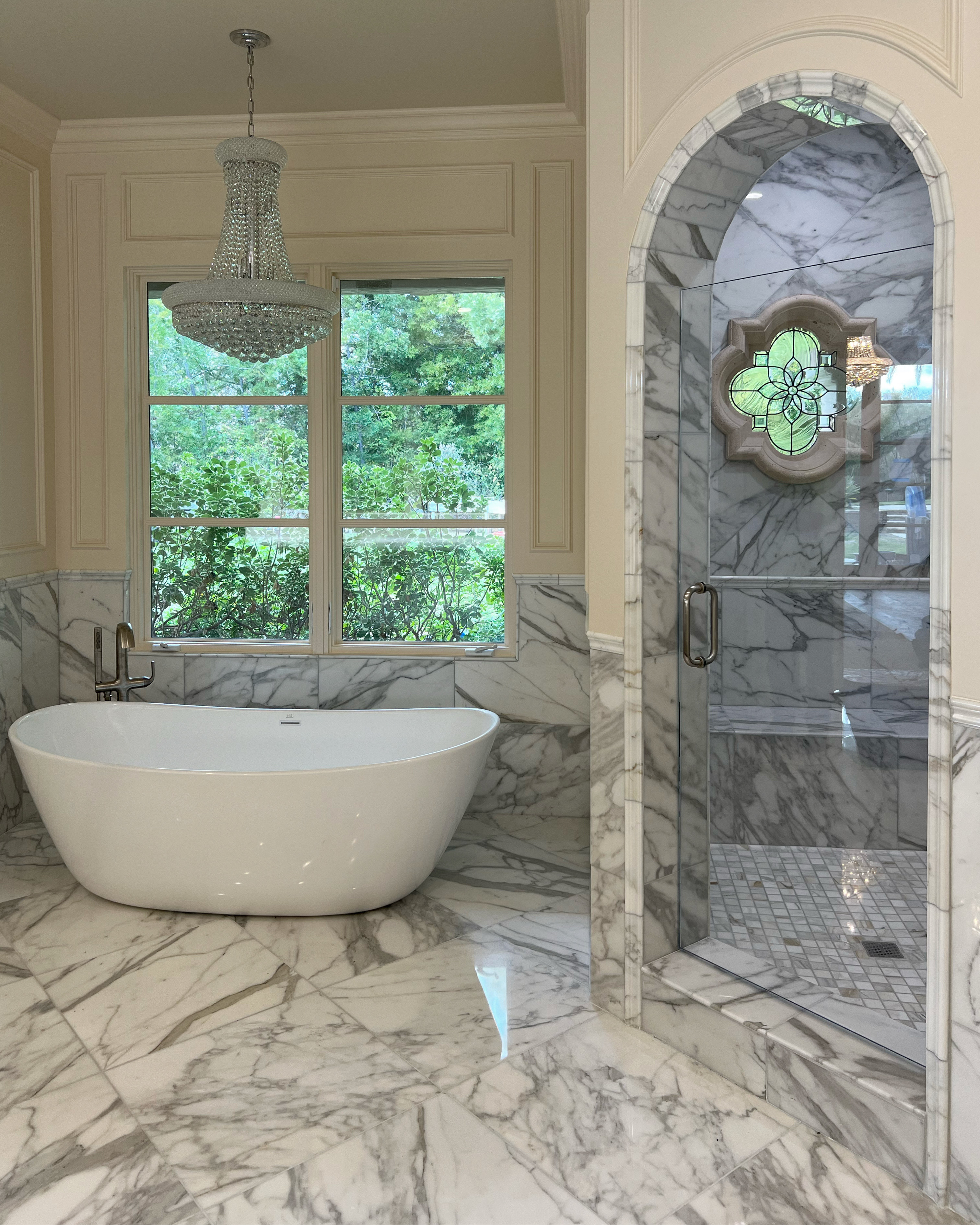 Classic marble bath with arched shower glass